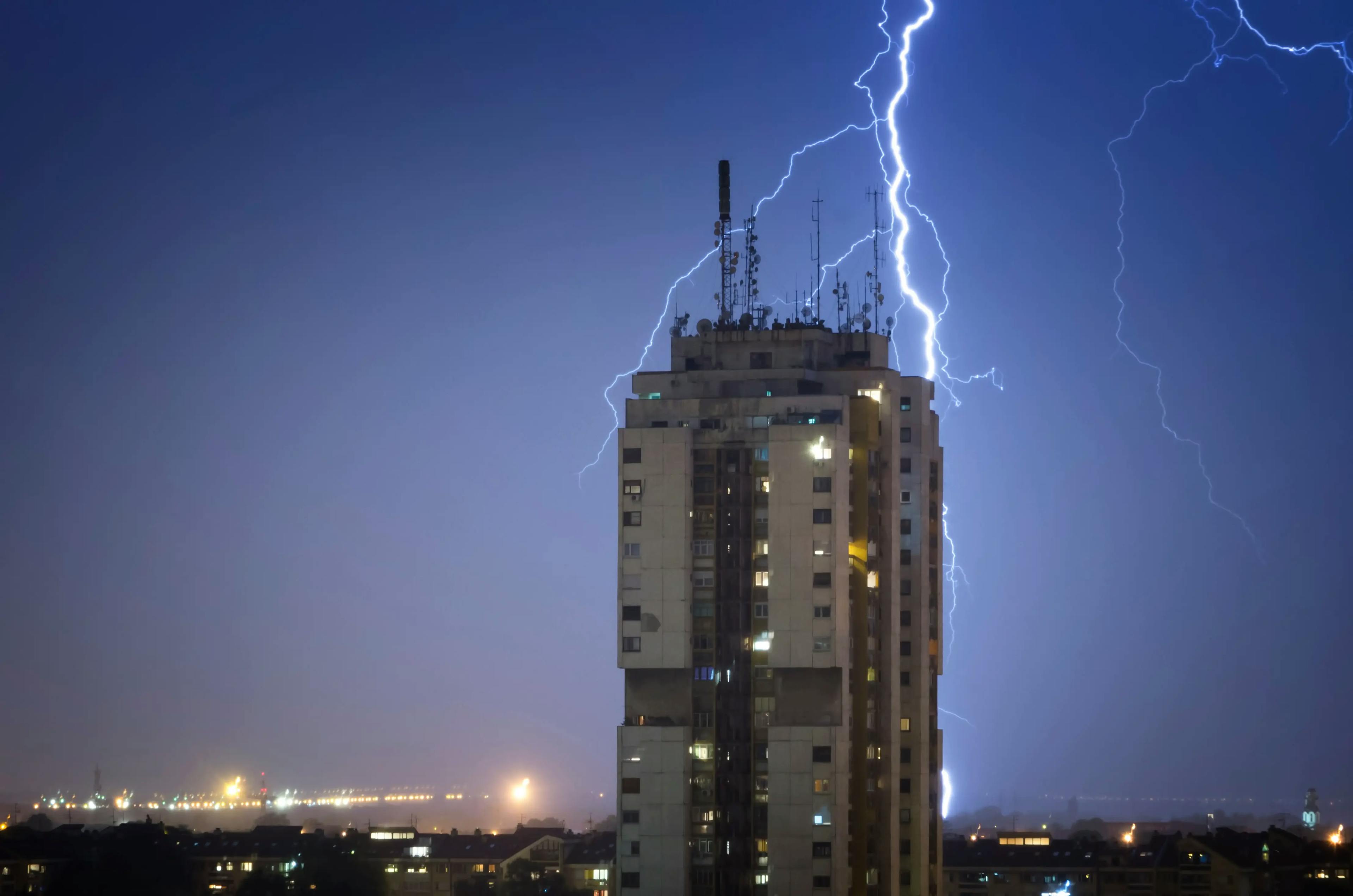 Foto de um edifício recebendo descarga atmosférica no pararaio